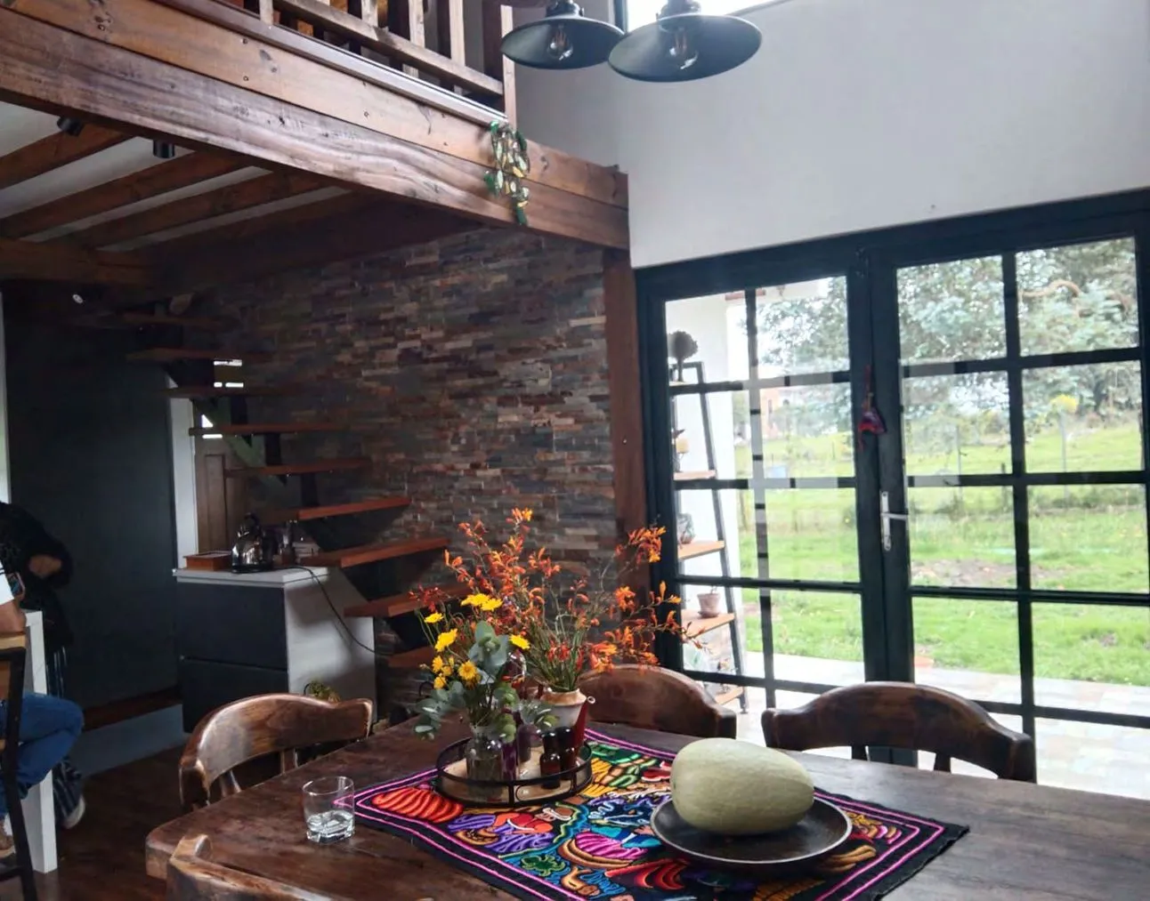 Acabado interior de comedor con pared de piedra pizarra y escalera