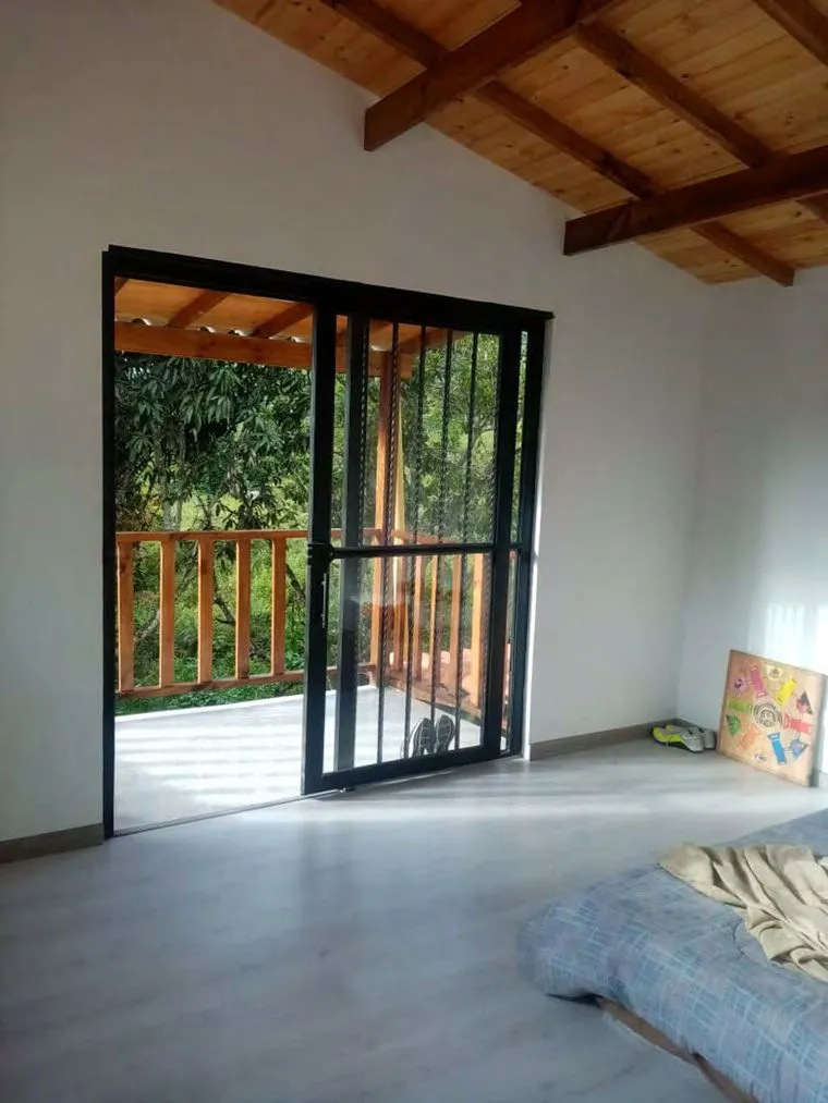 Acabado interior de habitación con techo de madera y balcón